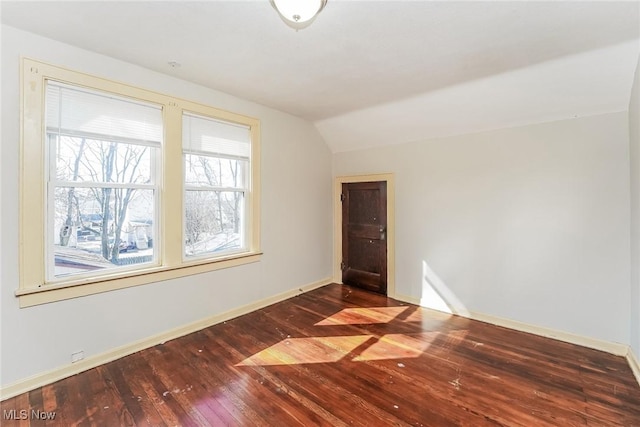 unfurnished room with baseboards, lofted ceiling, and hardwood / wood-style floors