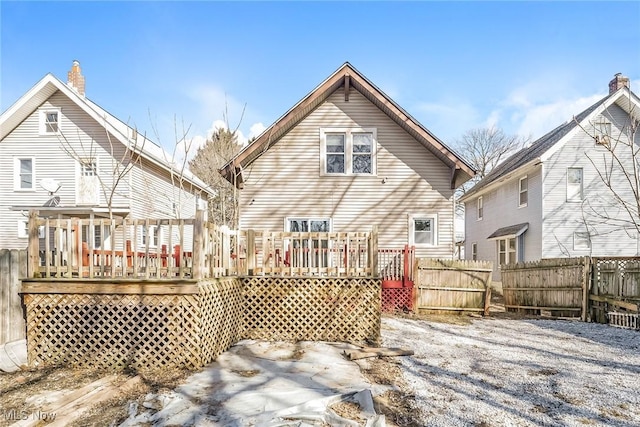 back of property with a deck and fence