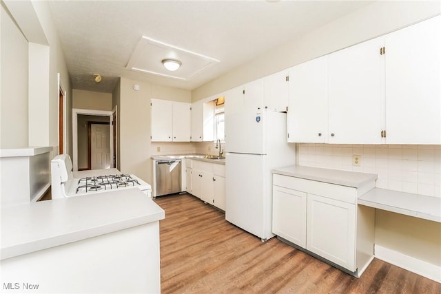 kitchen featuring light wood-style flooring, stainless steel dishwasher, white cabinetry, freestanding refrigerator, and range with gas cooktop