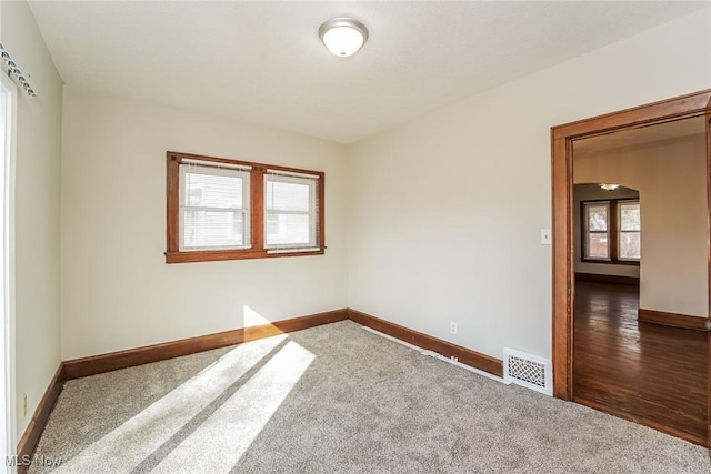 carpeted spare room featuring baseboards and visible vents