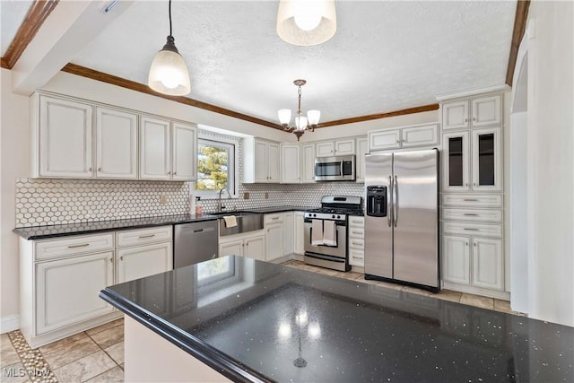 kitchen featuring a sink, a textured ceiling, appliances with stainless steel finishes, an inviting chandelier, and decorative backsplash