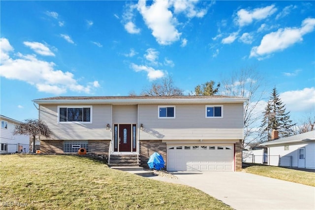 raised ranch with a front yard, fence, an attached garage, entry steps, and concrete driveway