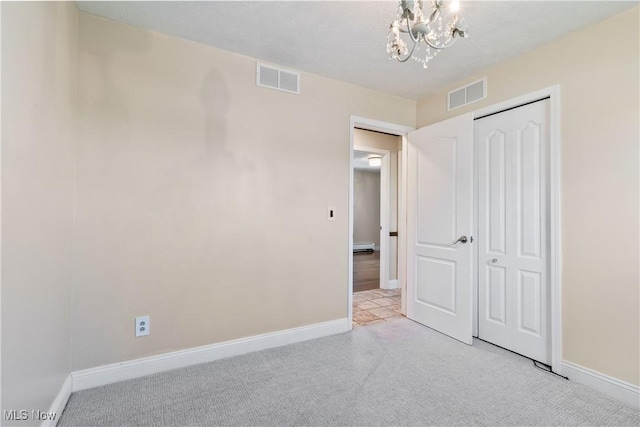 unfurnished bedroom featuring a notable chandelier, light colored carpet, visible vents, and baseboards