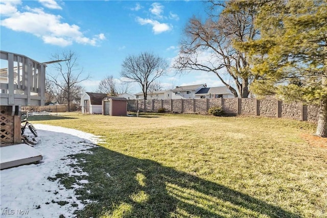 view of yard with an outbuilding, a fenced backyard, and a shed