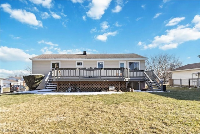 rear view of property with stairway, a lawn, a wooden deck, and fence