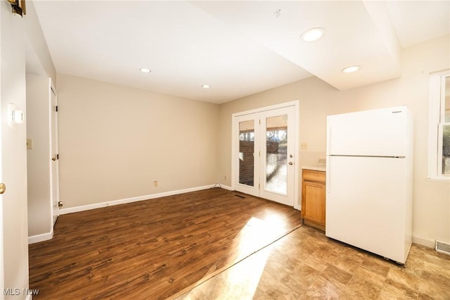 kitchen with visible vents, baseboards, and freestanding refrigerator