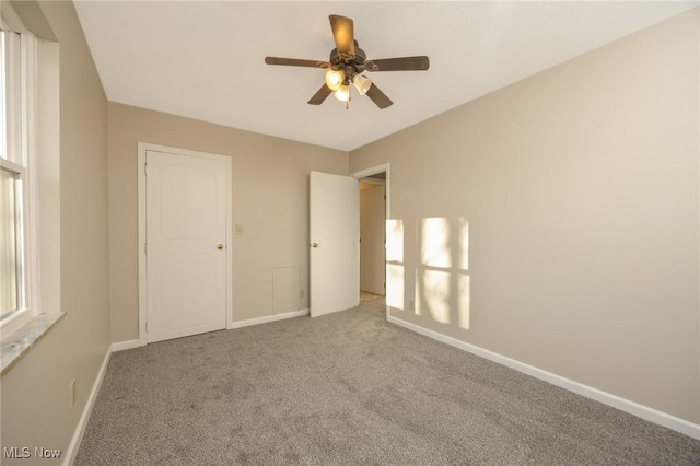 unfurnished bedroom featuring carpet flooring, a ceiling fan, and baseboards