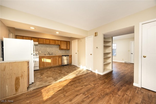 kitchen featuring brown cabinets, dark wood-type flooring, a sink, tasteful backsplash, and white appliances