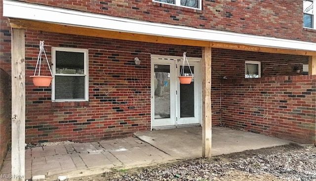 view of exterior entry with brick siding