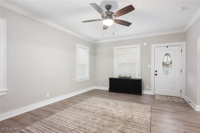 entrance foyer featuring ceiling fan, baseboards, wood finished floors, and crown molding