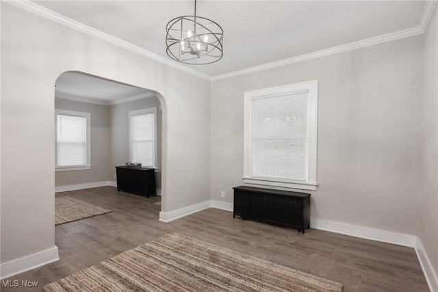 interior space with ornamental molding, wood finished floors, arched walkways, radiator, and baseboards