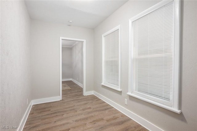 hall featuring baseboards and wood finished floors