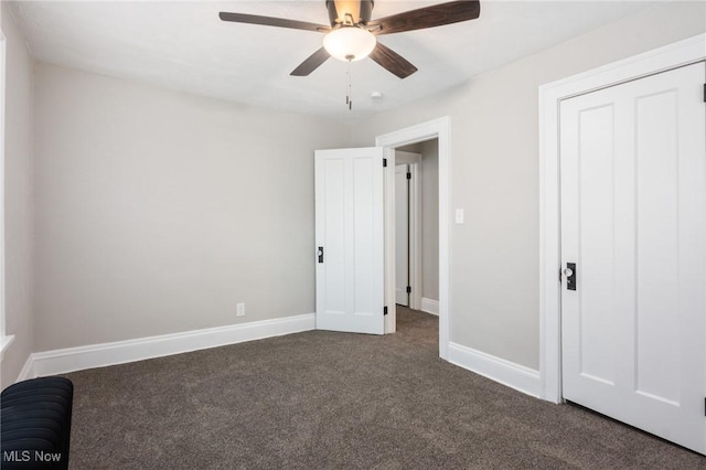 unfurnished bedroom with baseboards, a ceiling fan, and dark carpet