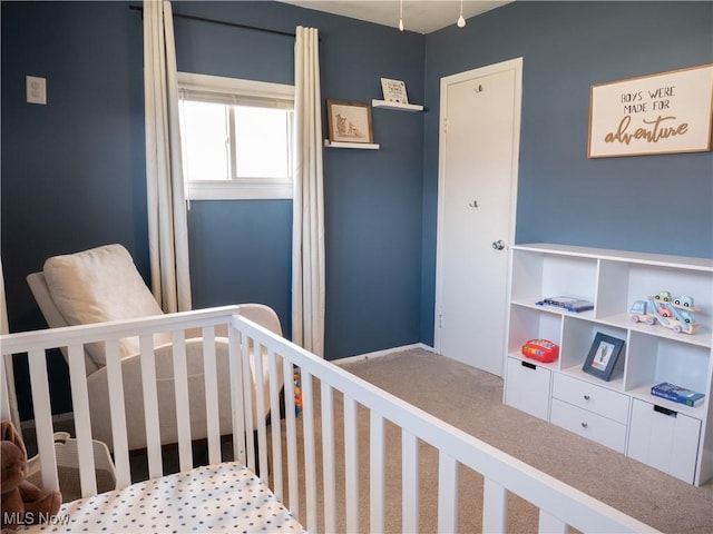 carpeted bedroom featuring a crib