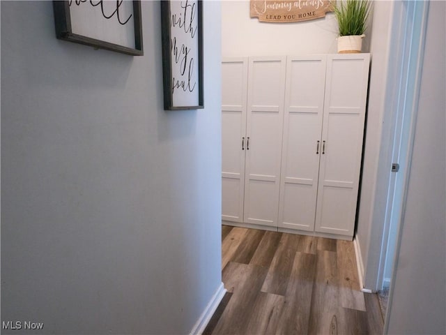 hallway with wood finished floors and baseboards