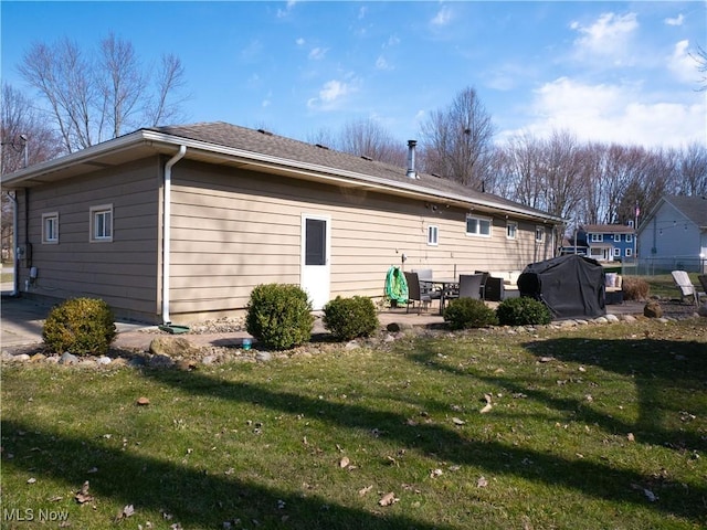 rear view of house featuring a lawn and a patio area