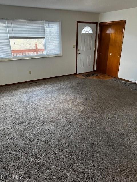 carpeted entrance foyer featuring baseboards