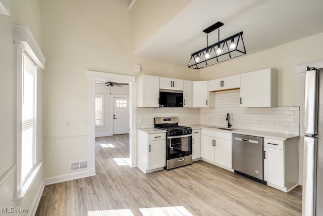 kitchen with light countertops, visible vents, appliances with stainless steel finishes, and a sink