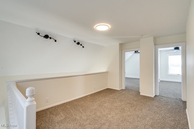 unfurnished room featuring baseboards, carpet floors, and vaulted ceiling