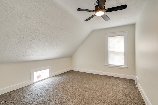 bonus room with vaulted ceiling, a textured ceiling, baseboards, and carpet floors