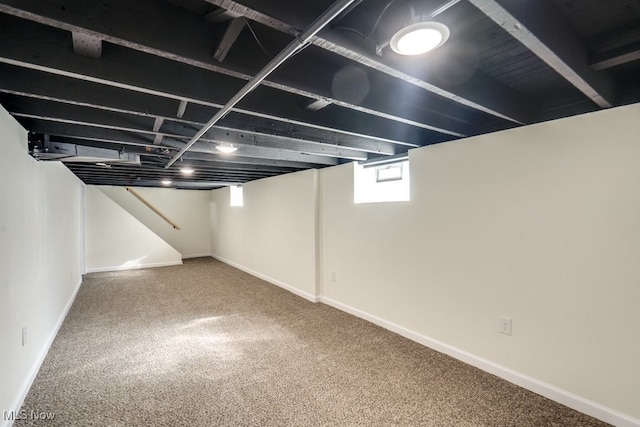 basement featuring baseboards and carpet floors