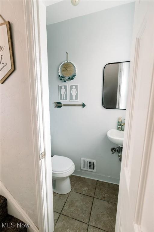 bathroom with tile patterned floors, visible vents, baseboards, and toilet