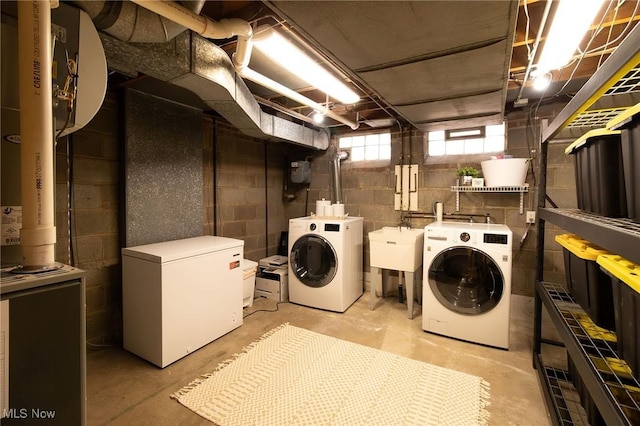 clothes washing area featuring laundry area, independent washer and dryer, and a sink