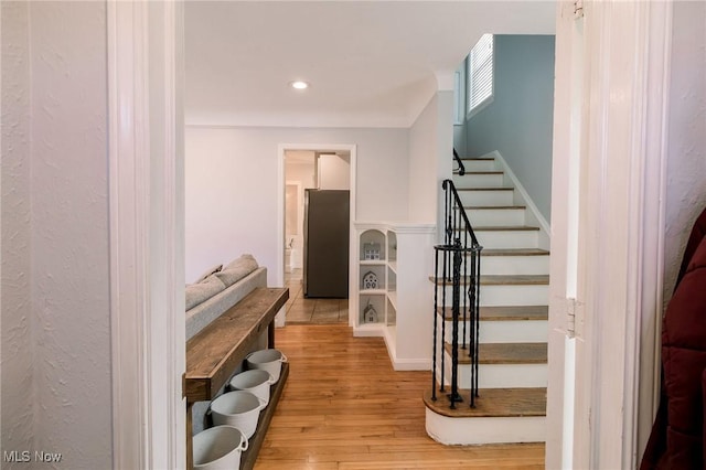 stairway with recessed lighting and wood finished floors