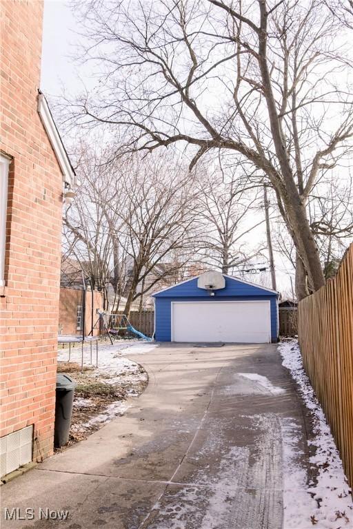 garage featuring a trampoline and fence