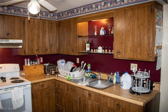 kitchen featuring a sink, light countertops, under cabinet range hood, and white range with electric stovetop