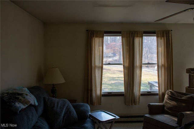 living area with a baseboard radiator and ceiling fan