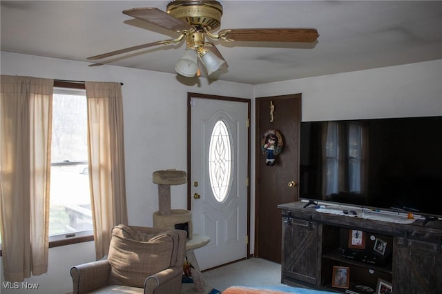 entryway featuring light carpet and a ceiling fan