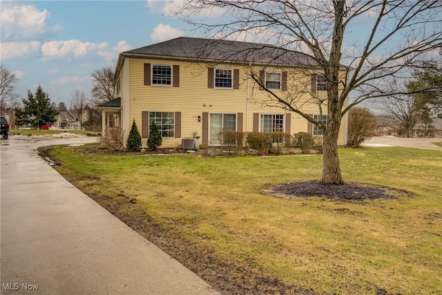 colonial inspired home featuring central AC and a front lawn