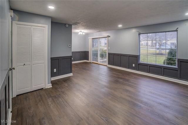 spare room with recessed lighting, wainscoting, and dark wood-style flooring