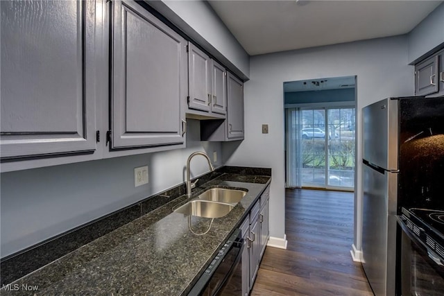 kitchen featuring a sink, gray cabinetry, dark stone counters, black appliances, and dark wood-style flooring