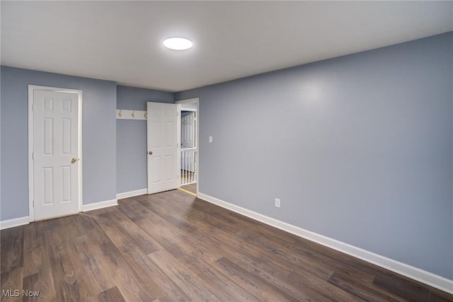 unfurnished bedroom featuring baseboards and wood finished floors