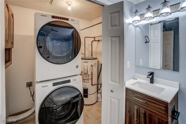 washroom with a sink, stacked washer / drying machine, electric water heater, and laundry area