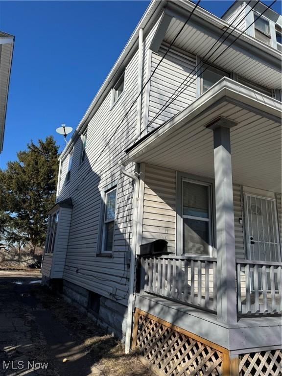 view of side of home featuring covered porch