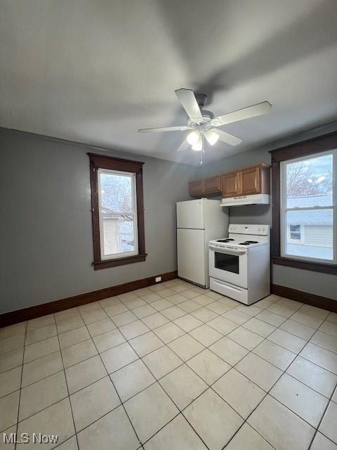 kitchen featuring white appliances, light tile patterned floors, baseboards, ceiling fan, and under cabinet range hood