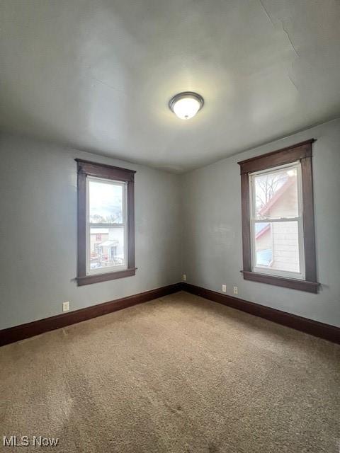 unfurnished room featuring baseboards and carpet