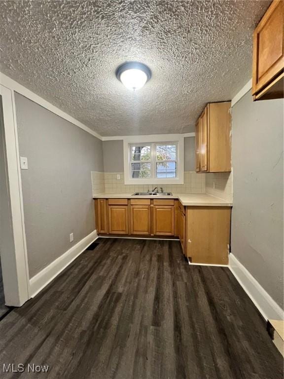 kitchen featuring light countertops, dark wood-style floors, and backsplash