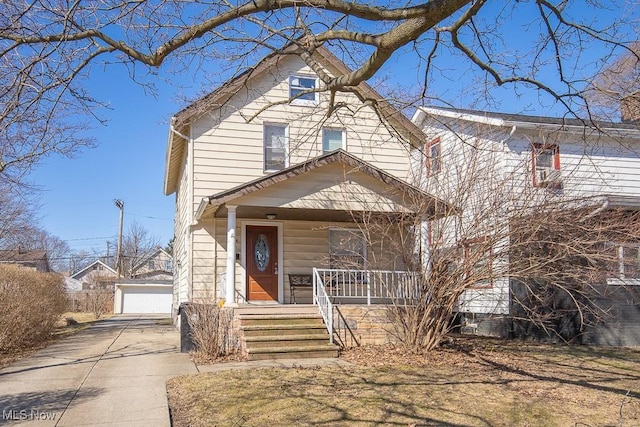 traditional style home with covered porch, a detached garage, and an outdoor structure