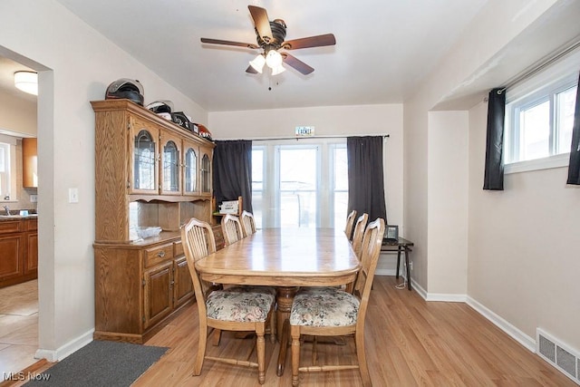 dining room with light wood-style flooring, baseboards, visible vents, and ceiling fan