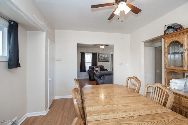 dining space featuring visible vents, baseboards, light wood-style floors, and ceiling fan