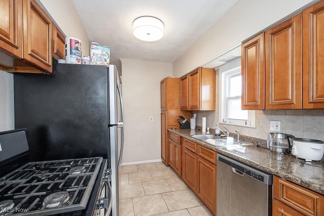 kitchen featuring a sink, stainless steel appliances, brown cabinets, and decorative backsplash