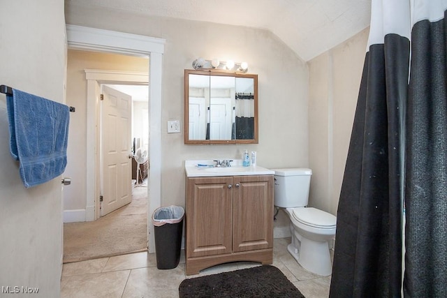 full bath with baseboards, toilet, lofted ceiling, tile patterned floors, and vanity