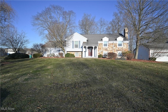 split foyer home featuring a front yard, stone siding, and a chimney