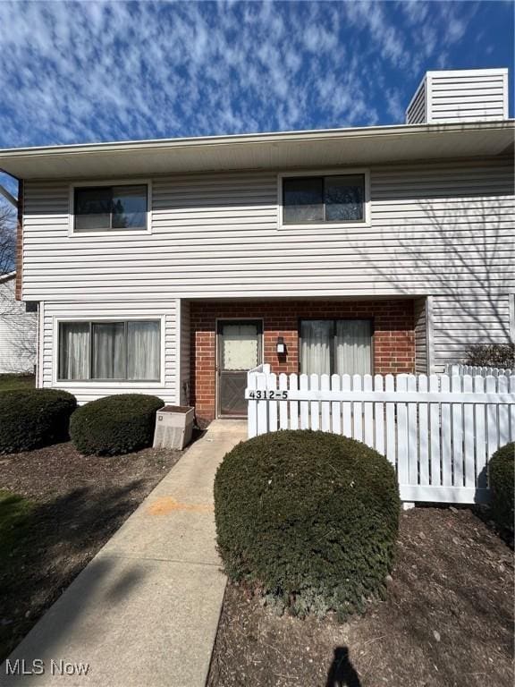 townhome / multi-family property featuring brick siding and fence