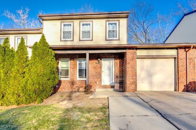 traditional home with brick siding, concrete driveway, and an attached garage