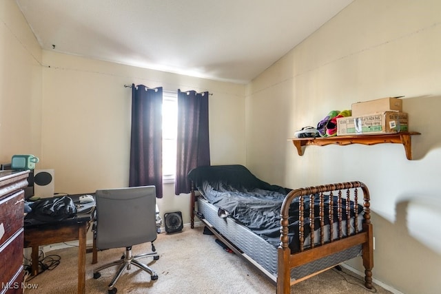 carpeted bedroom with lofted ceiling and baseboards